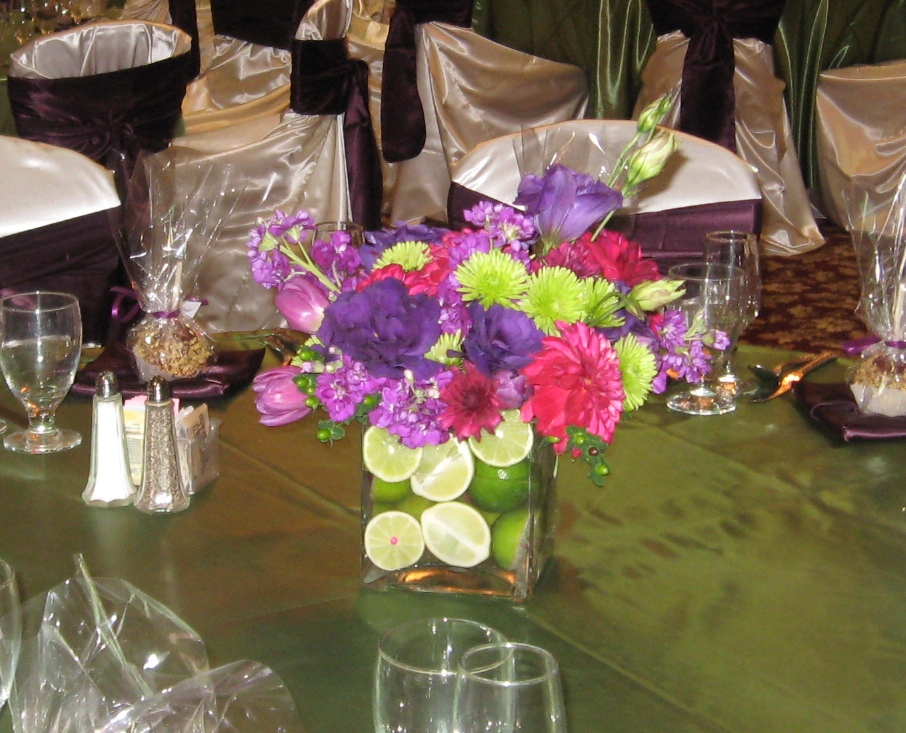Square vases filled with limes with wine purple and green flowers