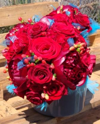 red roses red peonies berries and turquoise ribbon feathers