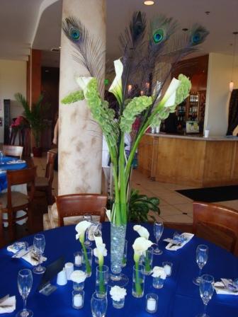 Pilsner vases with calla lilies bells of Ireland and peacock feathers