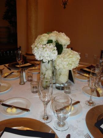 Short centerpieces of 3 vases one with an arrangement of roses hydrangea 