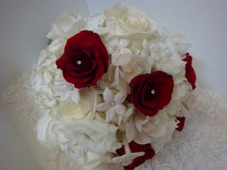 White bouquet with a few red roses studded with rhinestones