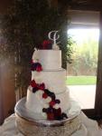 Beautiful cake by Debbie at Cakes to Celebrate. Cascade of ranunculas, roses and mini calla lilies.