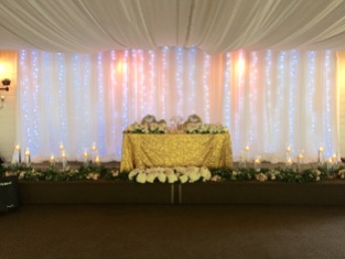 Stunning back drop with the flower bar, garlands, chair bouquets and candles all moved from the ceremony. Great way to reuse your ceremony items.